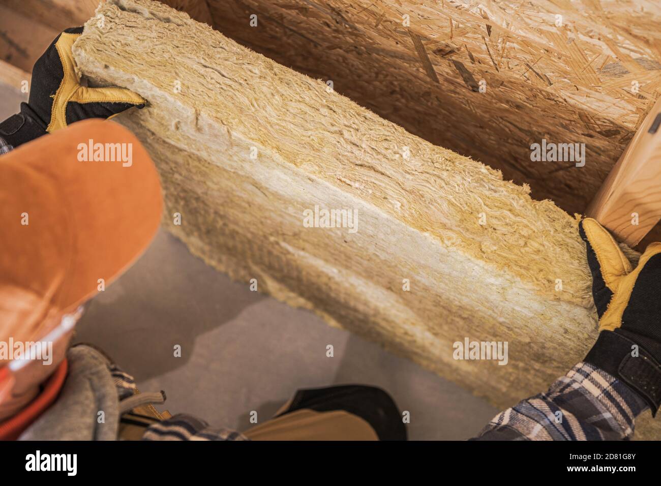 Isolamento in legno minerale Installazione all'interno di elementi a parete in legno per mantenere il calore all'interno dell'edificio. Appaltatore che posiziona pezzo di isolante. Costruzione Foto Stock