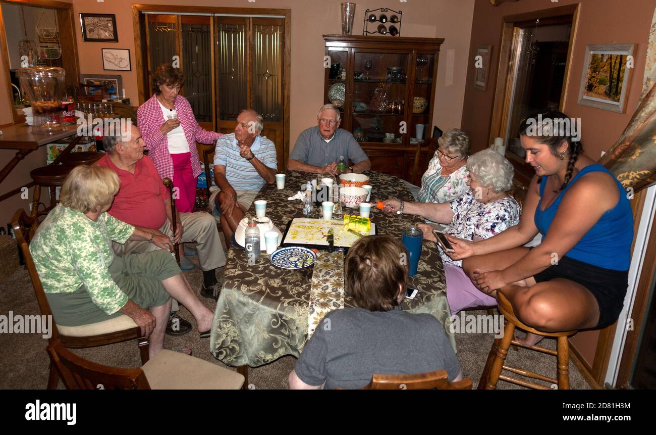 Famiglia adulti senior estesa che ricorda il tavolo dopo cena. Downers Grove, Illinois, Stati Uniti Foto Stock