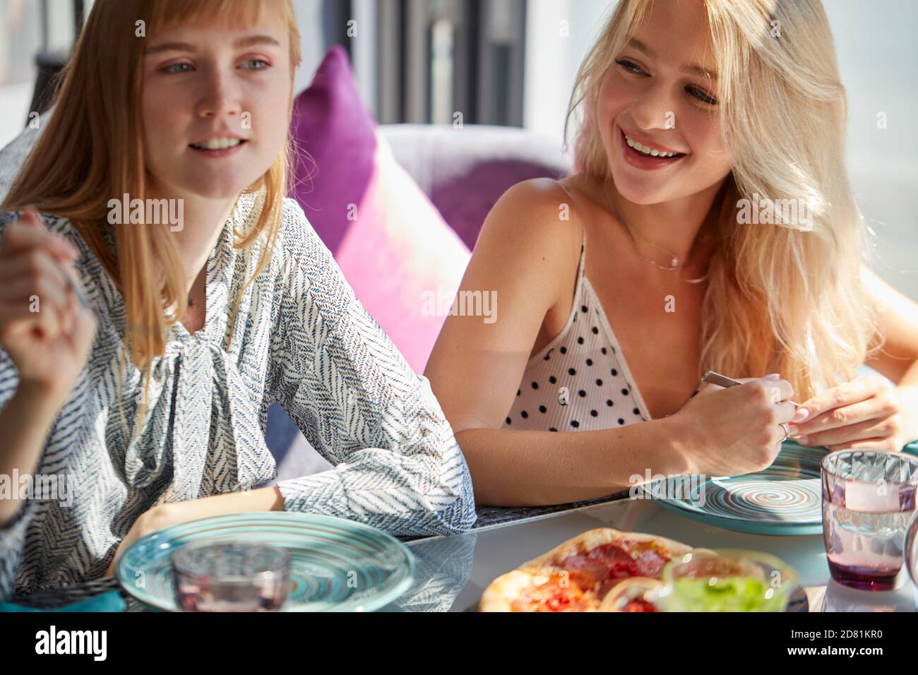 amici caucasici felici stanno riposando nel caffè che hanno pasto e divertimento, sono seduti ad un tavolo, parlano e condividono le notizie Foto Stock