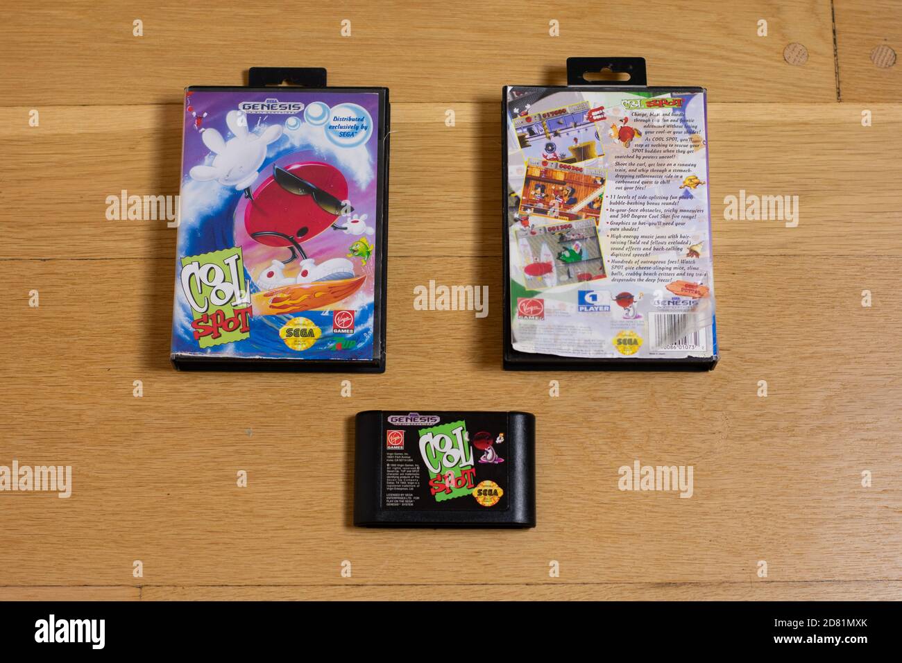 Una Cool Spot Cartridge e la parte anteriore e posteriore della sua Game Case per il sega Genesis su un pavimento in legno. Foto Stock