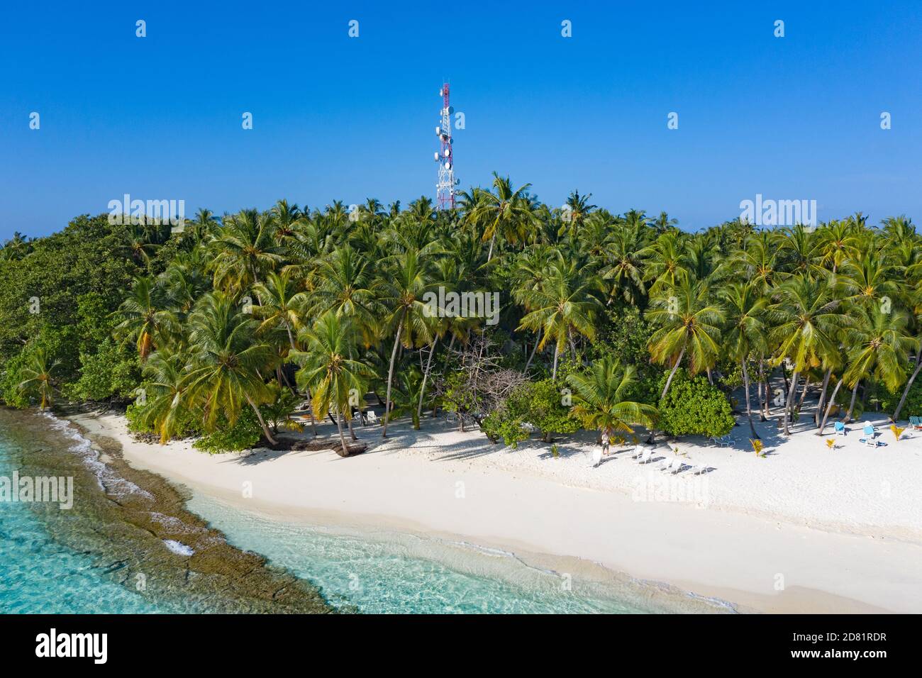 Piccola isola nelle Maldive coperta da palme e circondata da acque turchesi blu con bellissimi coralli e animali, perfetta fuga dal Foto Stock