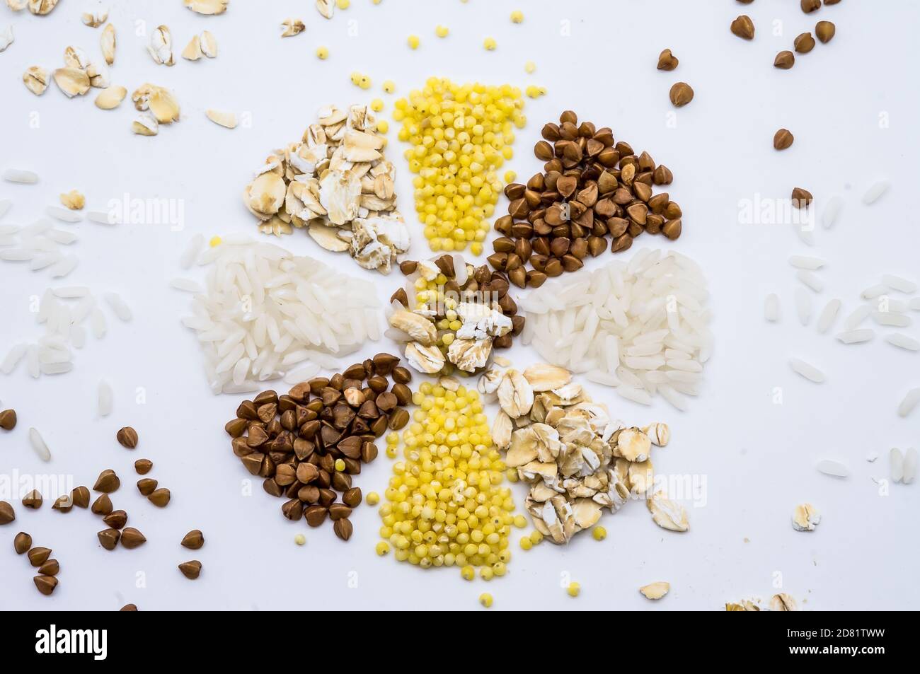 porridge a grani multipli, riso di farina d'avena e grano saraceno su fondo bianco, fiocco di neve da grani, fiore da cereali Foto Stock