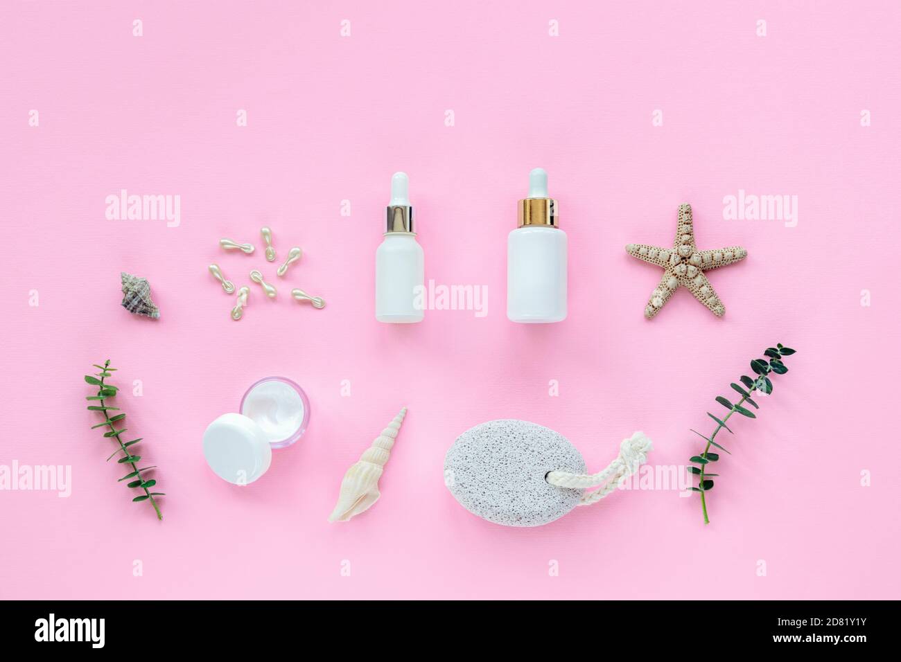 Prodotti naturali biologici per la cura della pelle. Siero, vasetto di crema, capsule di bellezza flaconi bianchi senza marchio. Stelle marine, pietra pomice, conchiglia e eucalipto Foto Stock