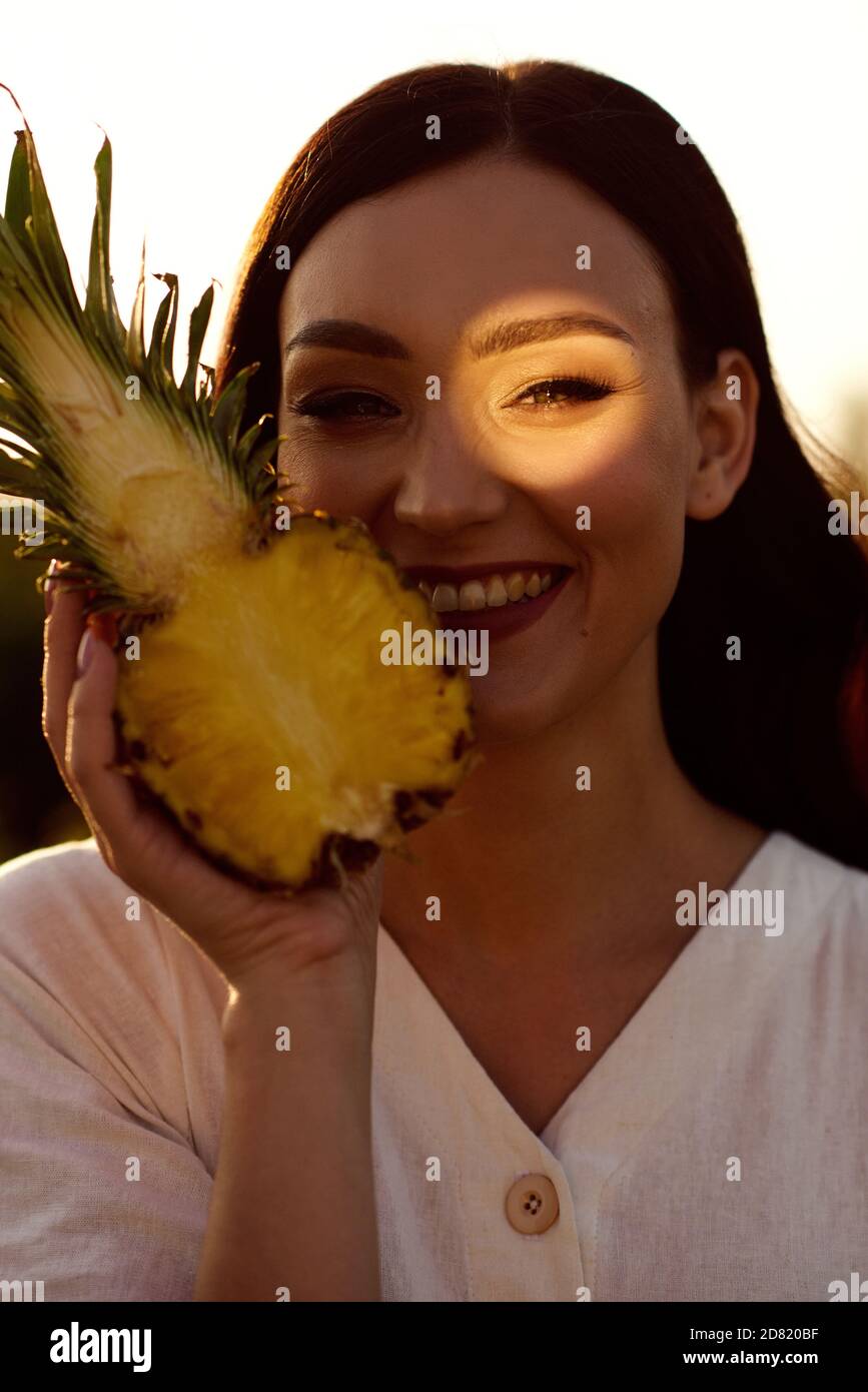 Ragazza che tiene in mano un ananas tagliato. Foto Stock