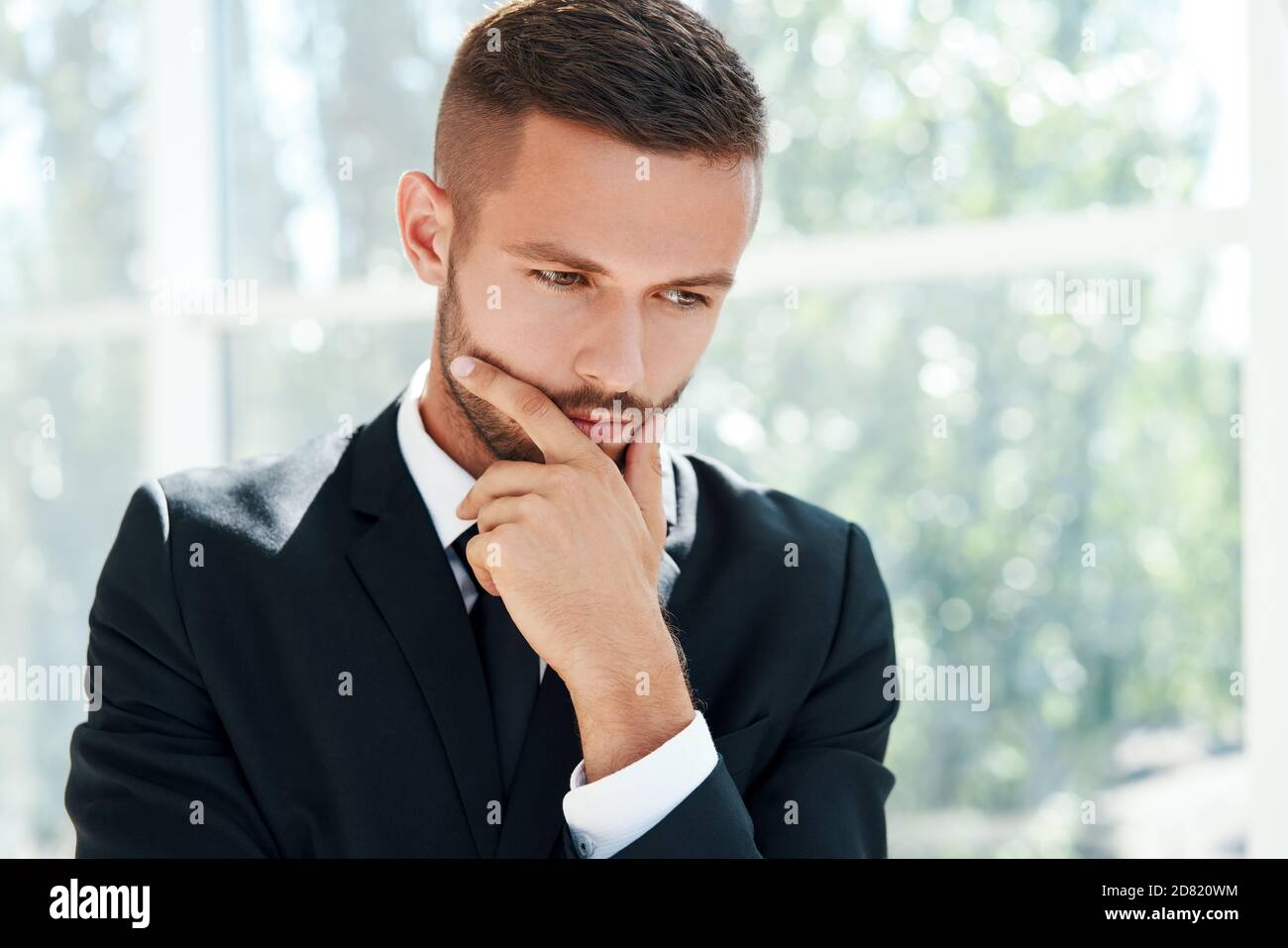 Ritratto di un uomo d'affari in un moderno ufficio creativo con spazio per la copia. Concetto di dubbio, soluzione, decisione ed emozioni Foto Stock