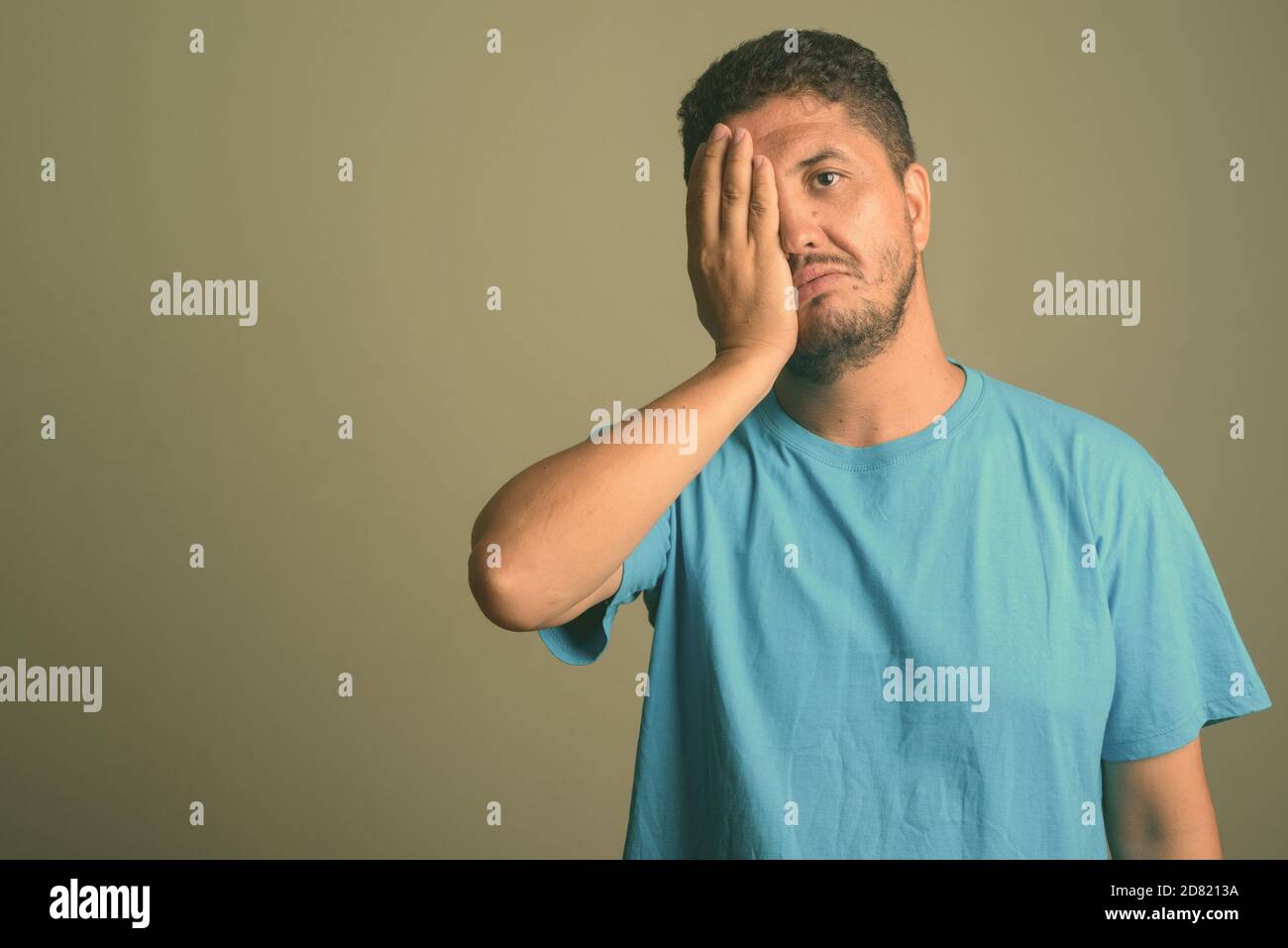 Uomo persiano con bearded che indossa una camicia blu su sfondo colorato Foto Stock