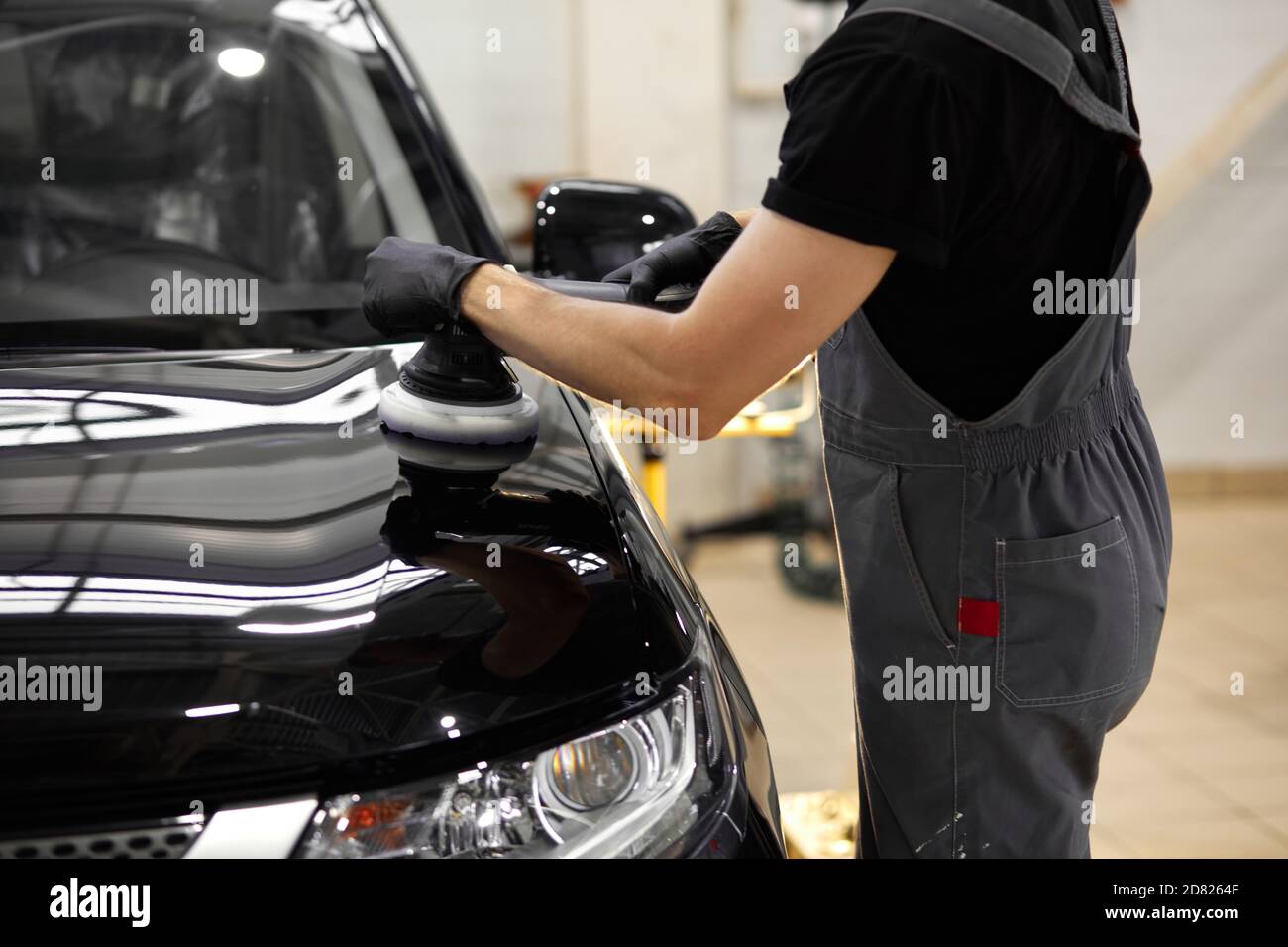 dettagli auto e lucidare concetto. giovane caucasico professionale di servizio auto lavoratore maschile, auto meccanica con lucidatrice orbitale, concetto di automobile Foto Stock