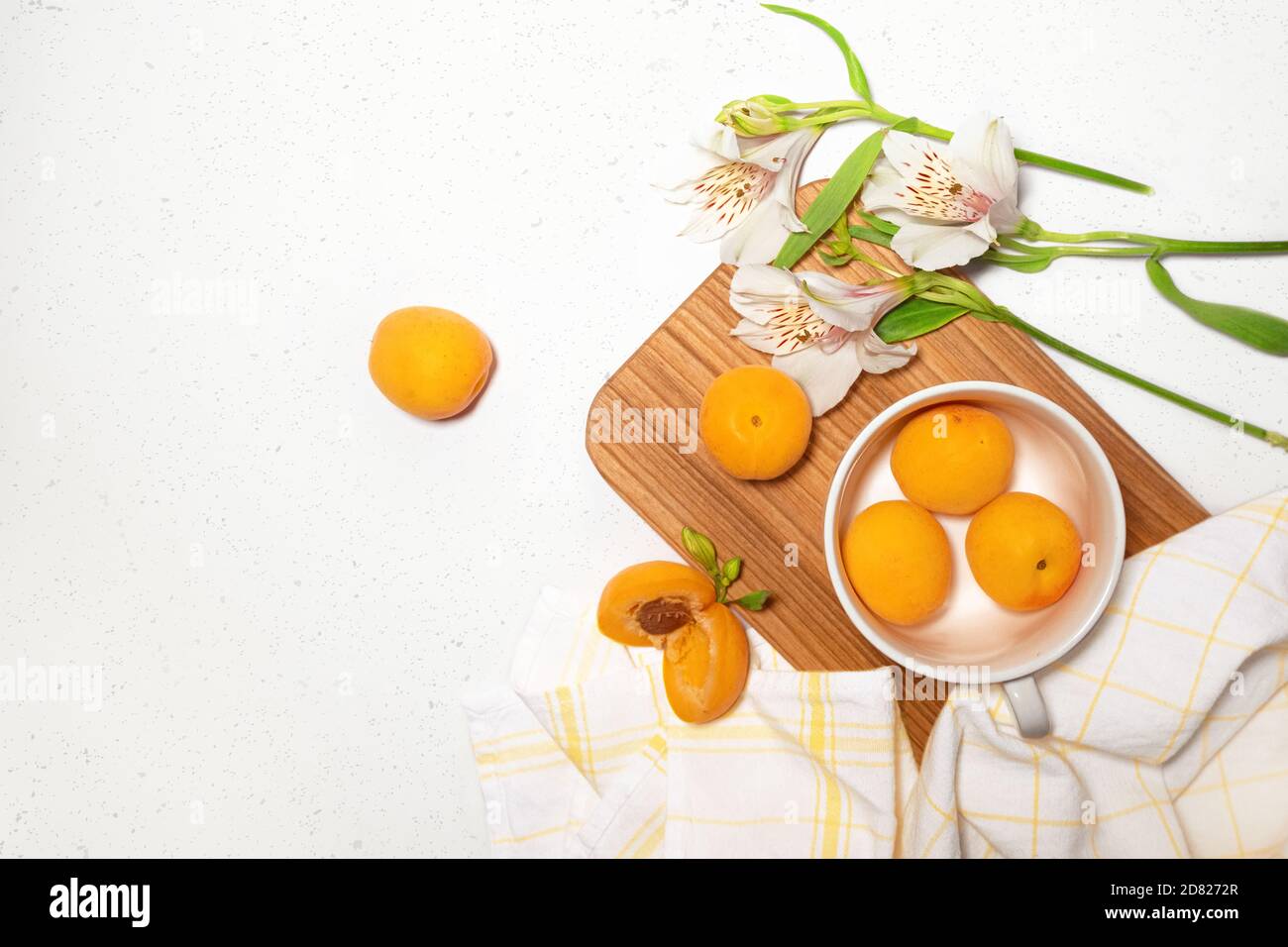 Composizione di albicocche con scrivania in legno su sfondo bianco di cemento. Banner Web culinario. Piatto. Spazio per il testo. Posiziona per il testo Foto Stock