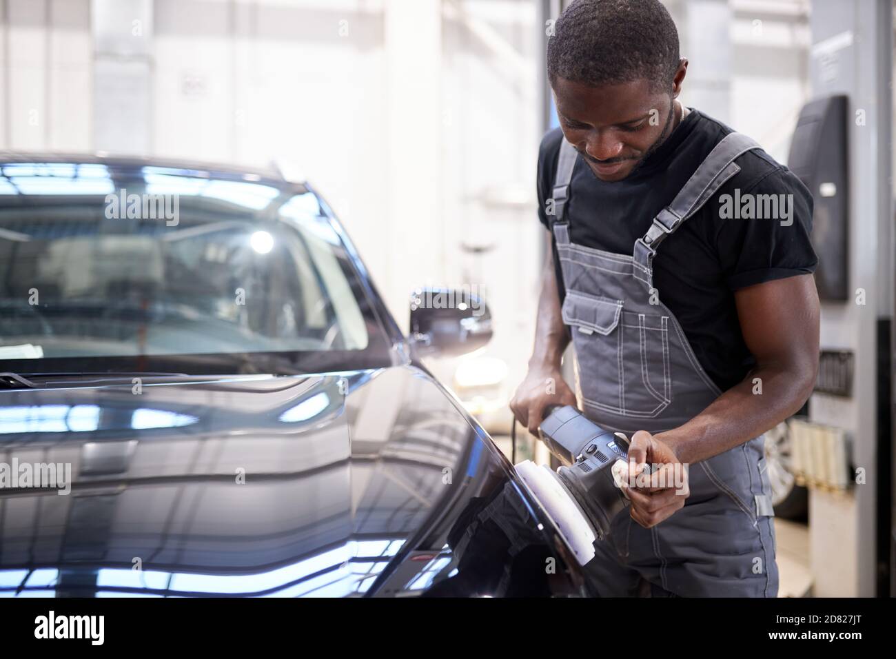 automobile che descrive e lucidare il concetto. giovane lavoratore professionista africano di automobile di servizio, meccanico di automobile con lucidatrice orbitale, concetto di automobile Foto Stock