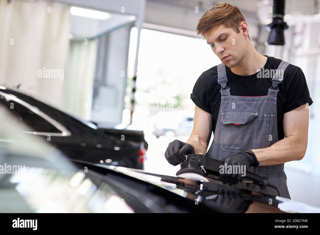 automobile che descrive e lucidare il concetto. giovane professionista di servizio di automobile lavoratore maschio, meccanico di automobile con lucidatrice orbitale, concetto di automobile Foto Stock