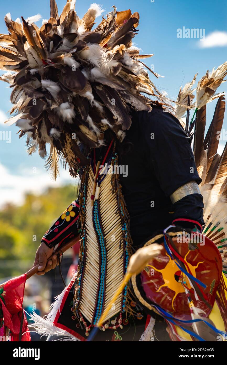 Outaouais, Québec - 19 settembre 2020: Artista non riconosciuto con la piuma vicino al viso nella fiesta culturale che si esibisce nel parco Foto Stock