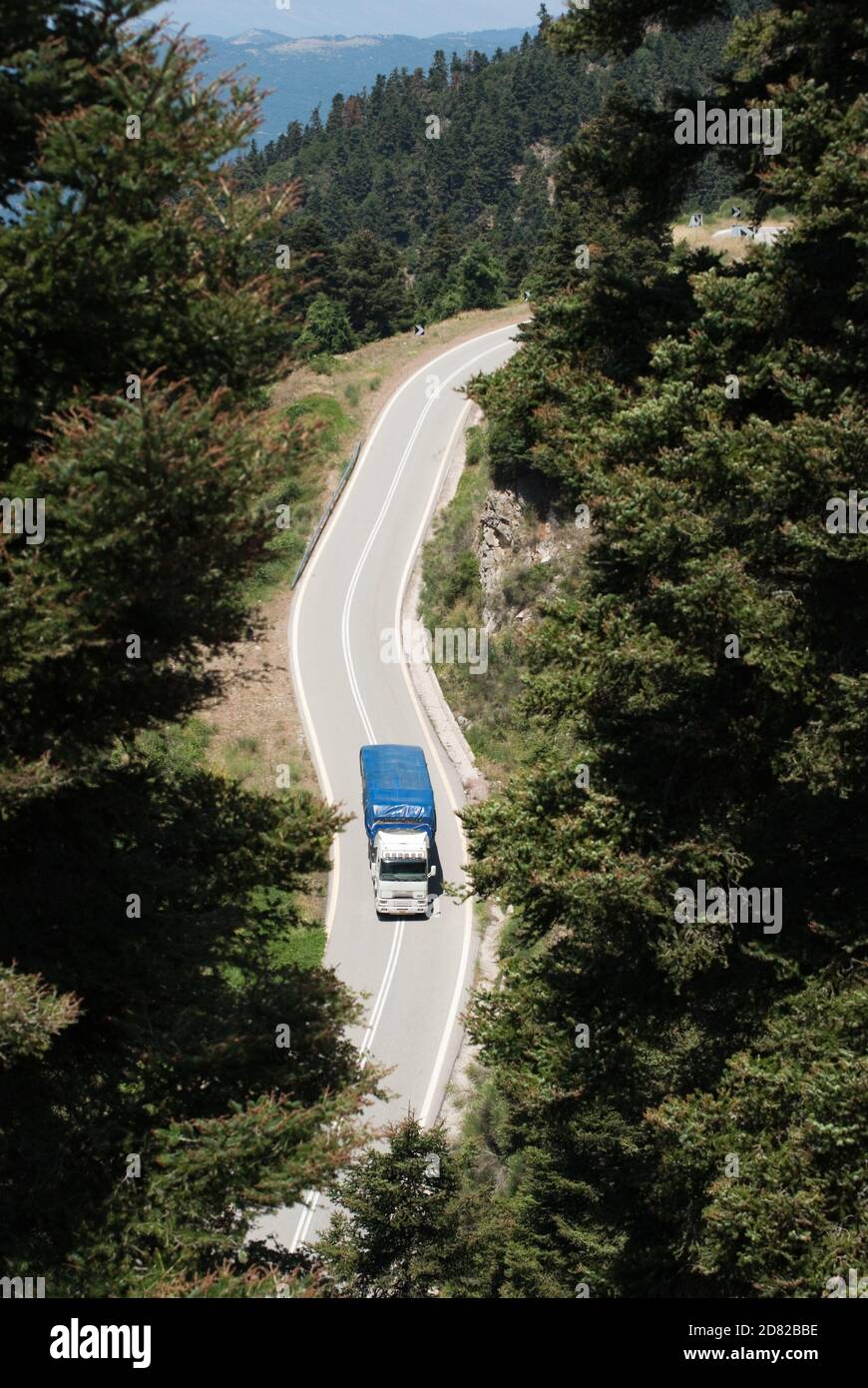 Vista aerea di un camion che attraversa una foresta di una strada di montagna in Grecia Foto Stock