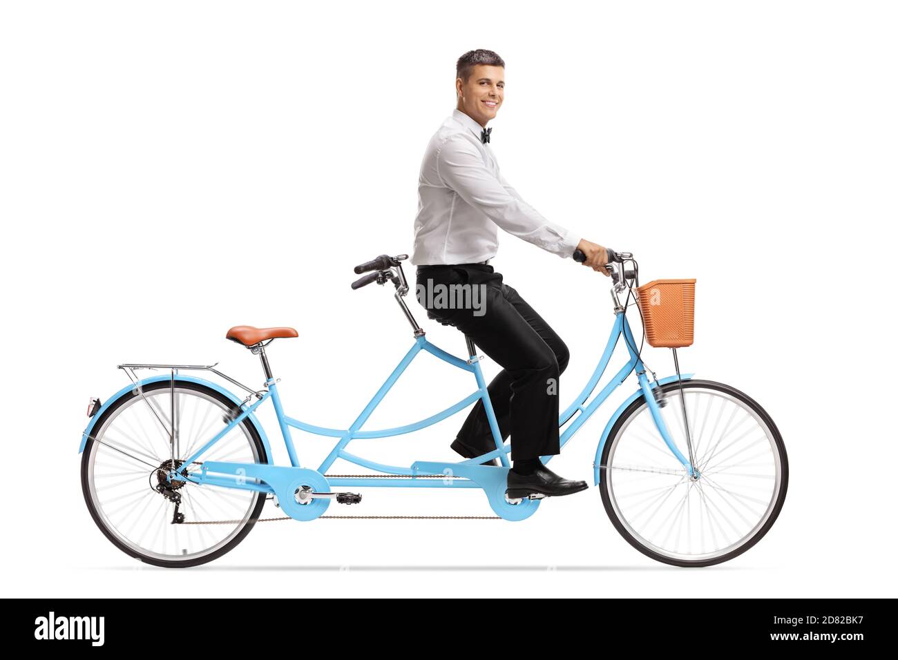 Foto di profilo a lunghezza intera di uno sposo sorridente che cavalca un bicicletta in tandem isolata su sfondo bianco Foto Stock