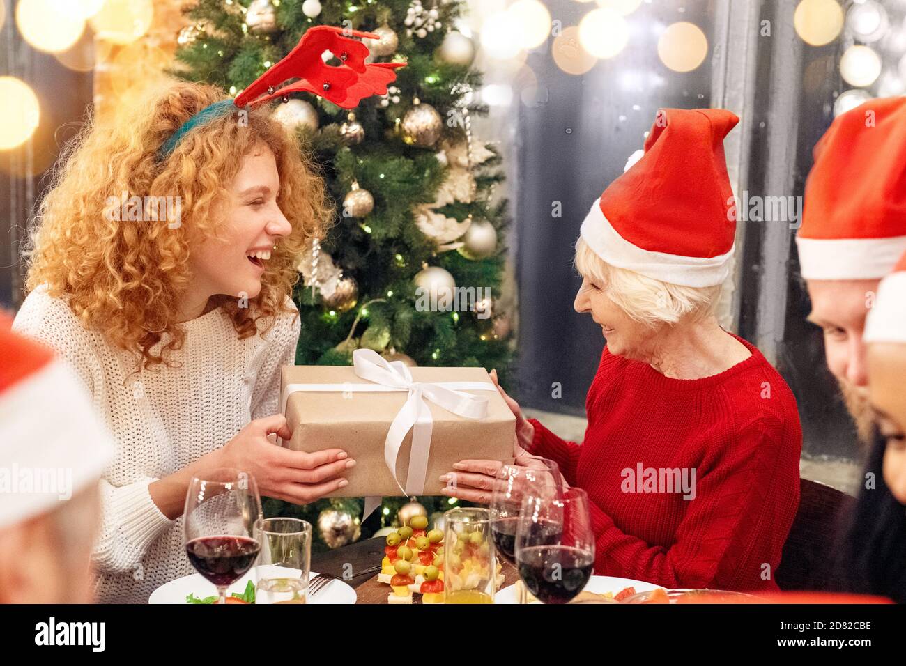 Donna felice che dà la scatola presente alla sua nonna Foto Stock