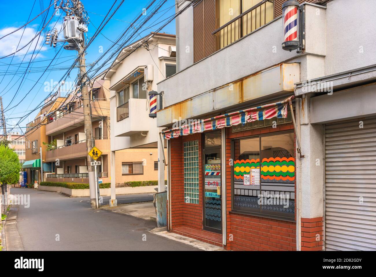 tokyo, giappone - ottobre 20 2020: Strada di quartiere del quartiere di Kanegafuchi con un cartello stradale di avvertimento per la zona della scuola e un arredamento per barbiere Foto Stock