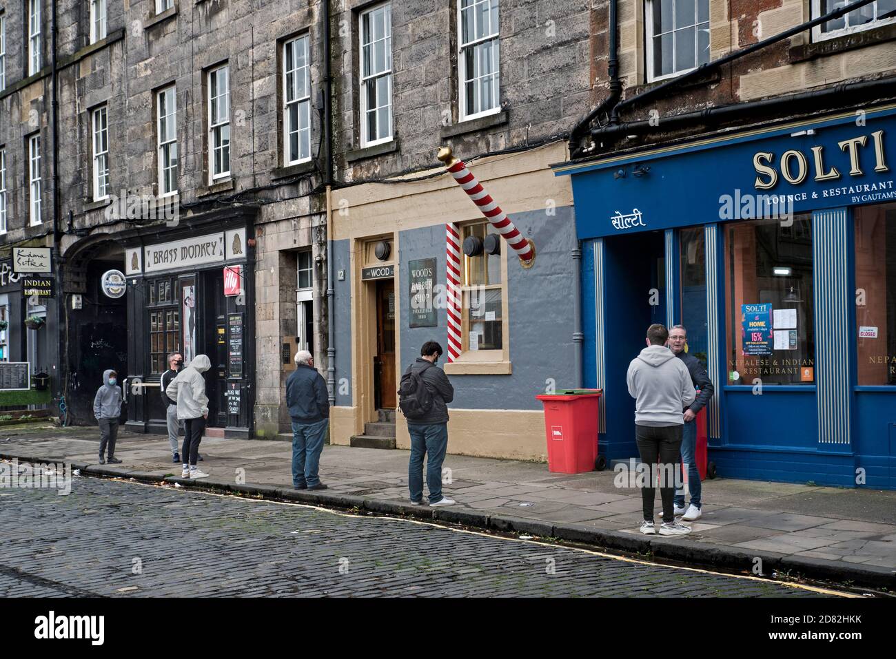 Coda socialmente distanziata per Woods Barbers su Drummond Street, Edimburgo, Scozia, Regno Unito. Foto Stock