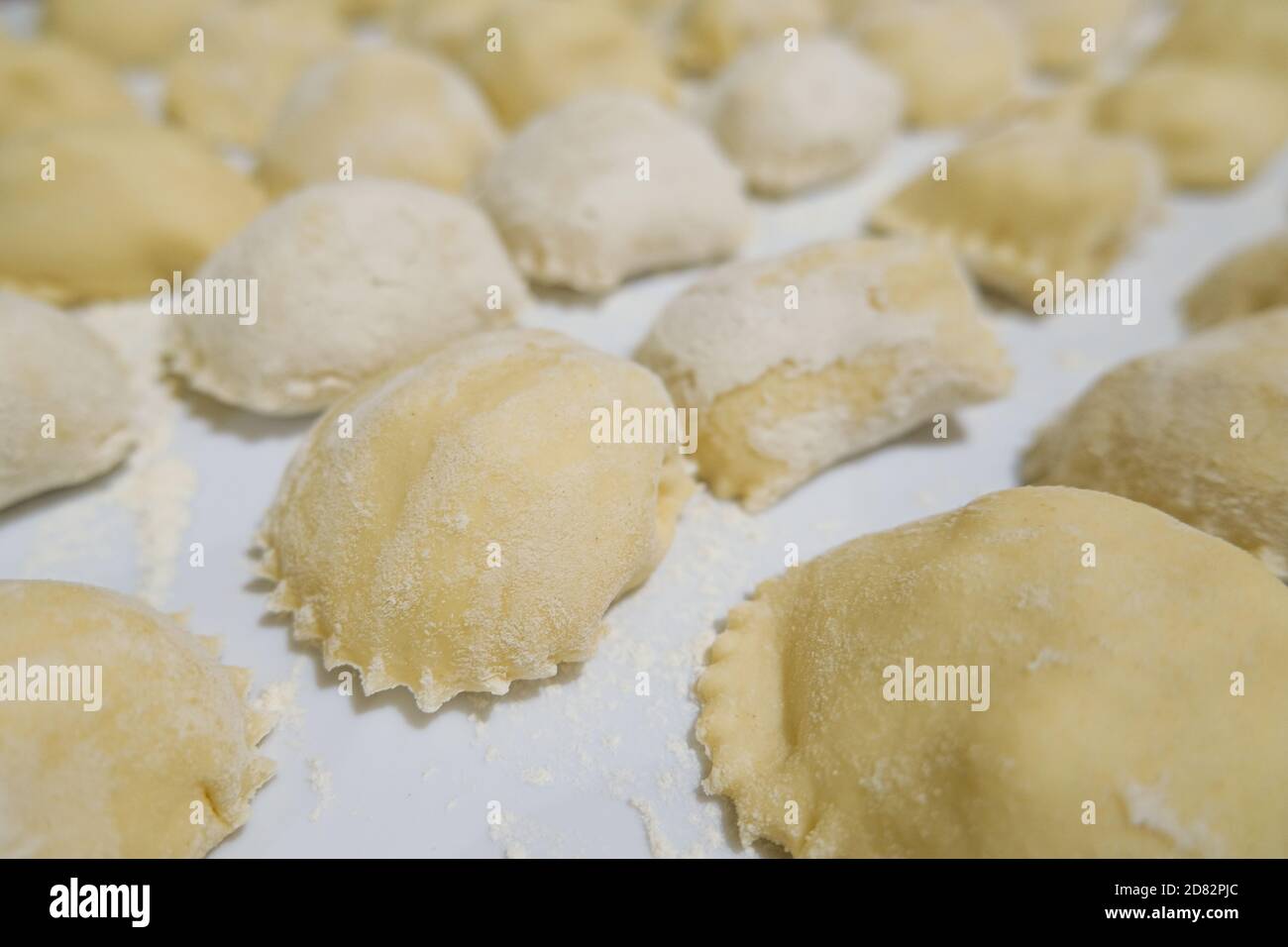 Primo piano con la pasta di ravioli italiani appena fatta a mano a casa, cibo sano Foto Stock