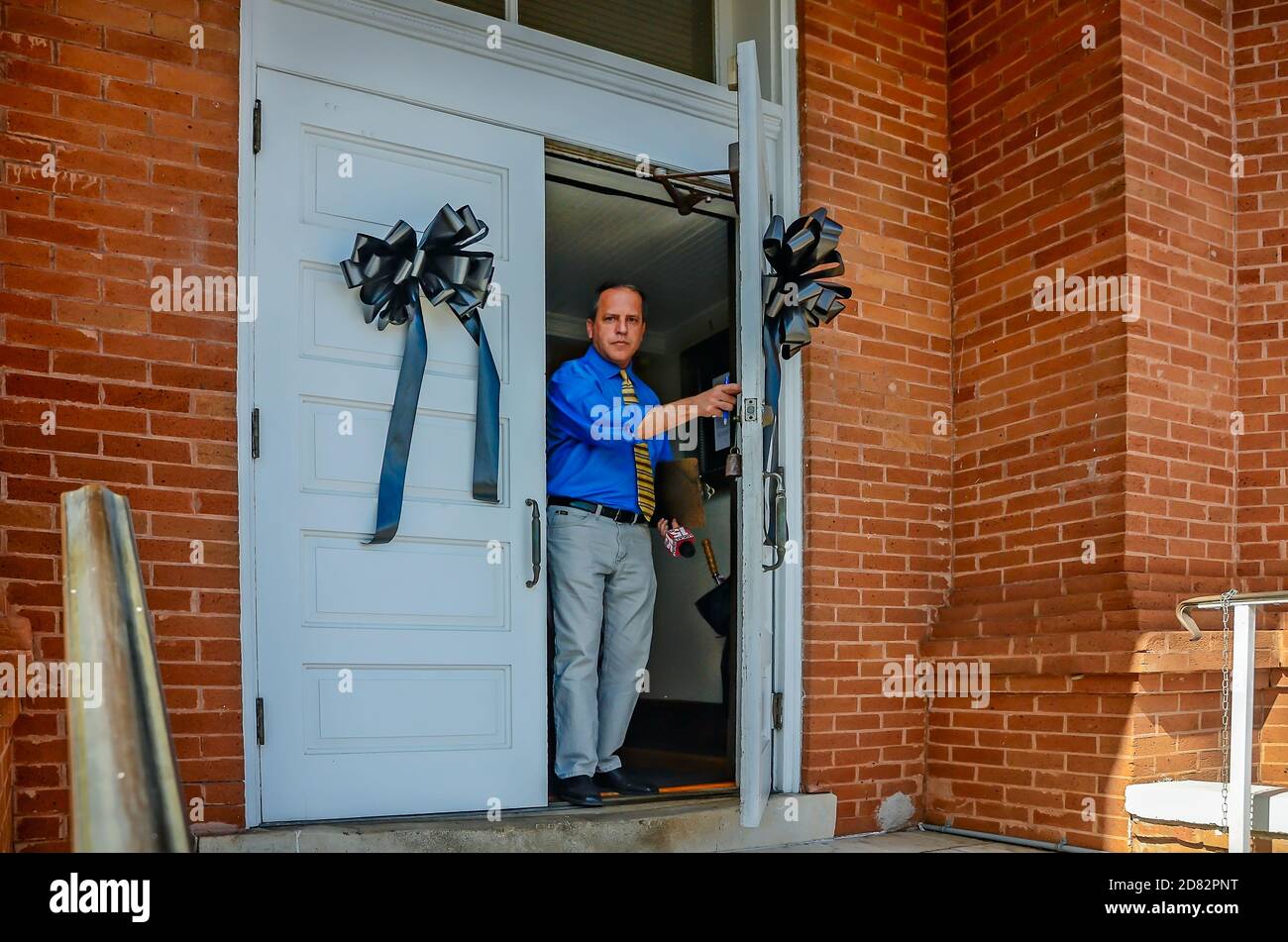 Un uomo esce dall'Old Courthouse Museum, dove i nastri neri pendono dopo la morte dell'autore locale Harper Lee, 19 febbraio 2016, a Monroeville, Alabama. Foto Stock