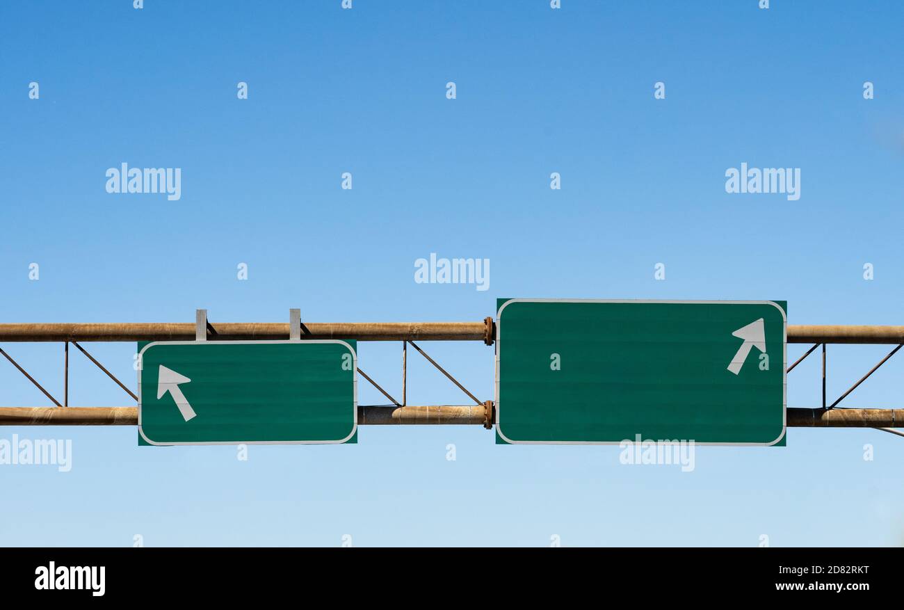 cartelli stradali vuoti in verde e bianco con frecce puntando in direzioni opposte Foto Stock