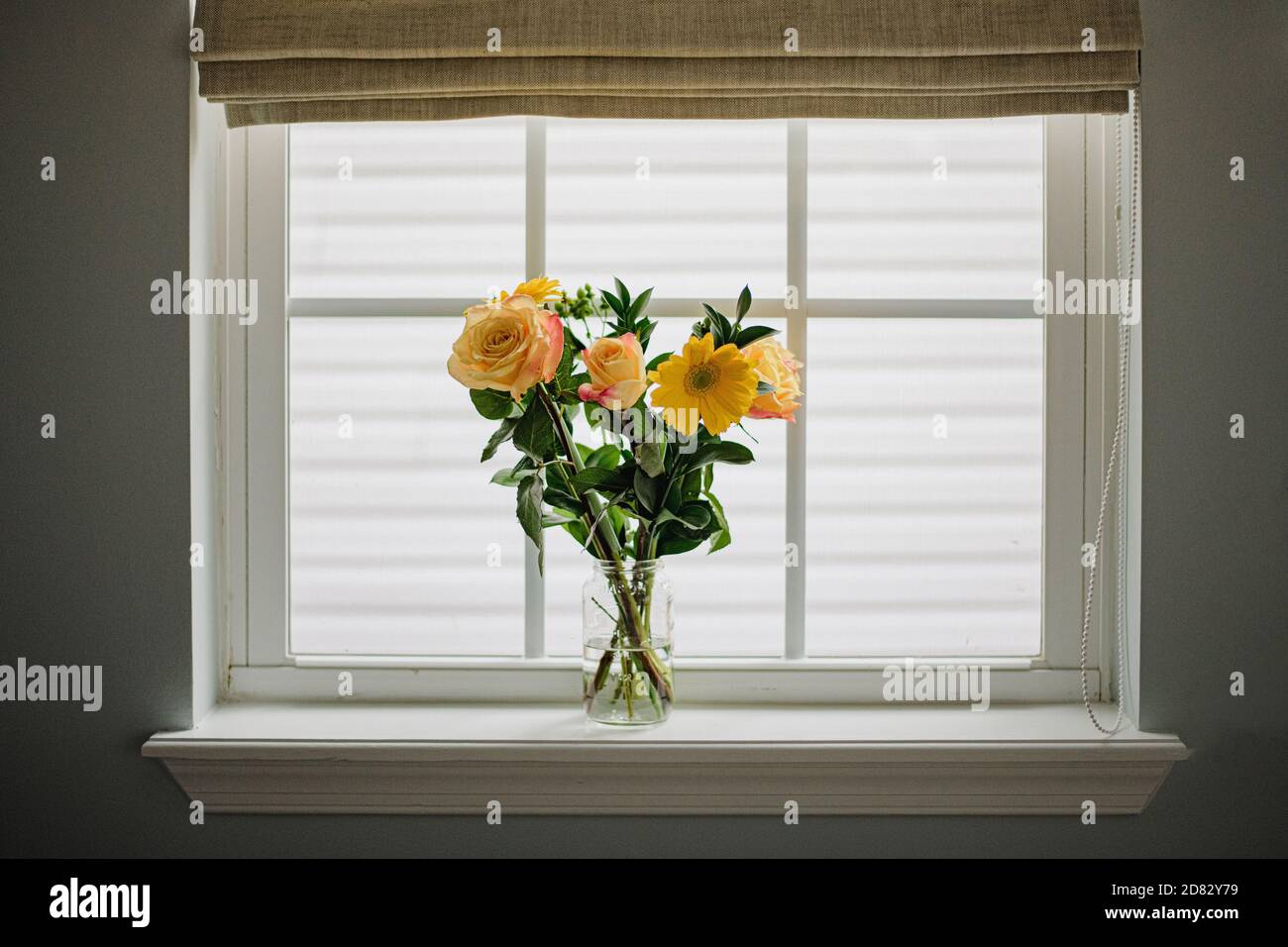 Bouquet di fiori gialli in vaso di muratore sul davanzale della finestra Foto Stock