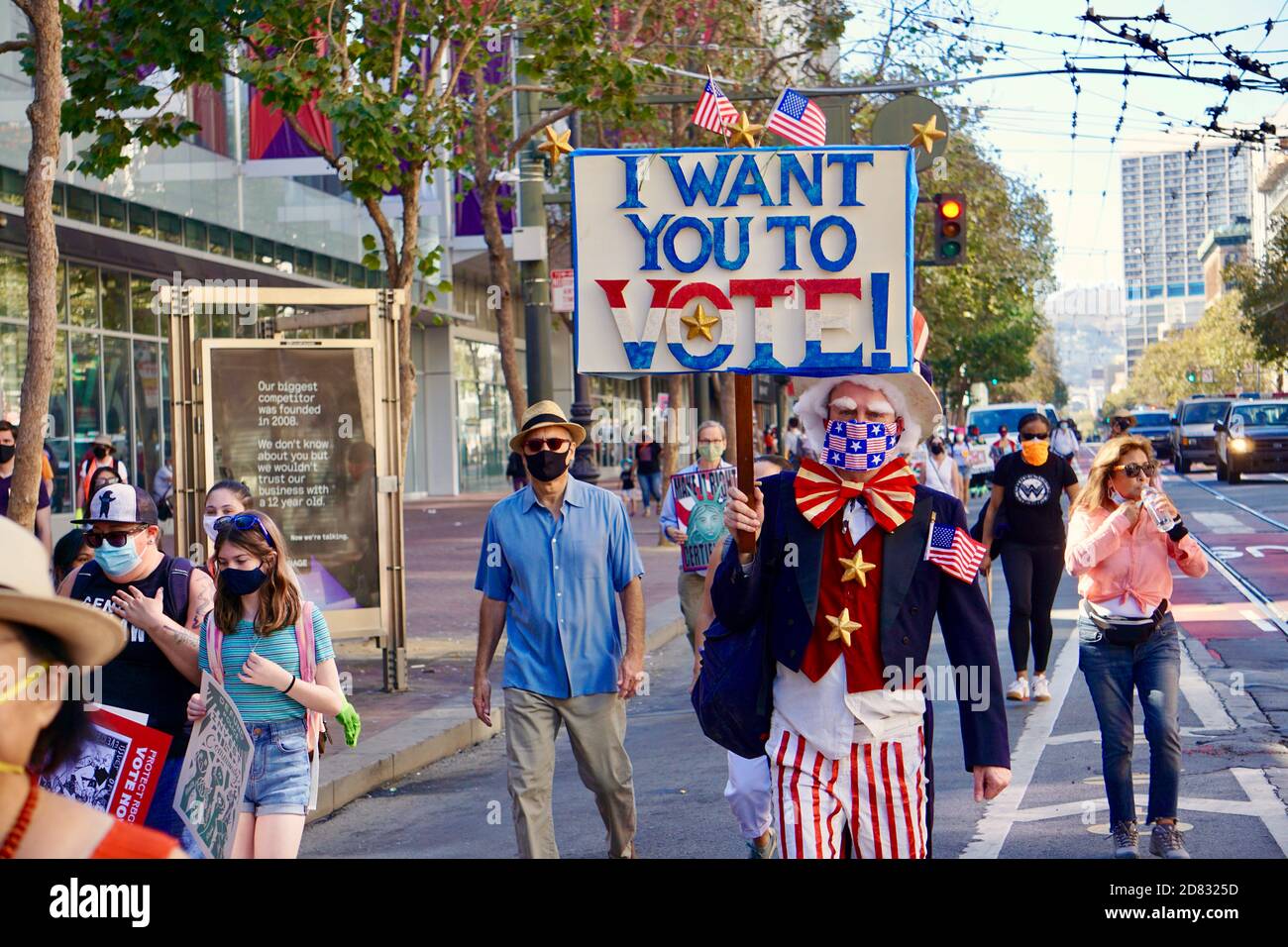 17 ottobre 2020. Il protetore vestito come zio Sam porta un segno di voto prima dell'elezione su Market Street alla marcia delle donne di San Francisco. San Francisco, California. Foto Stock