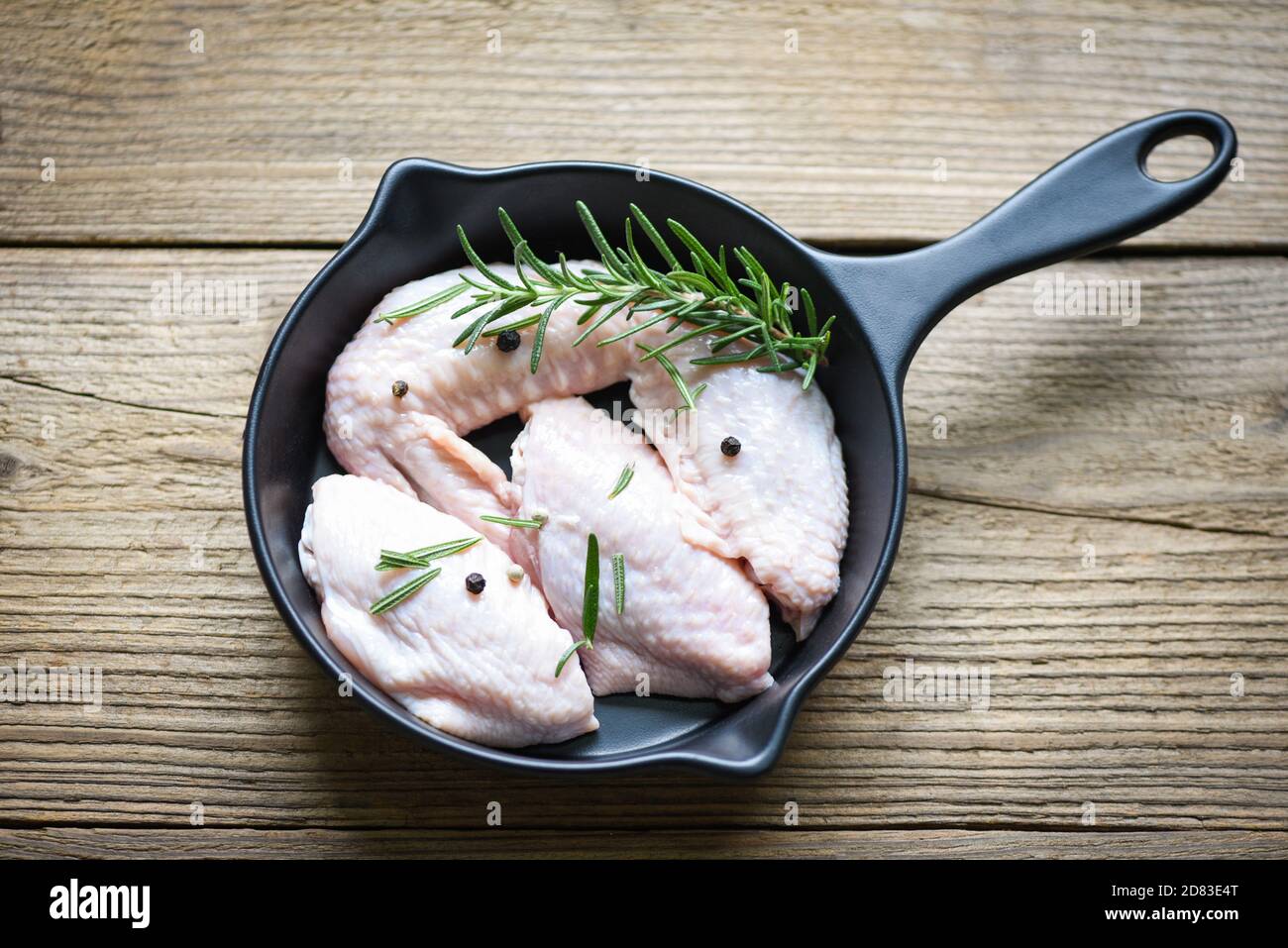 Raw chicken wings, herbs and spices with pepper chili for cooking thai asian food rosemary chicken, top view. Foto Stock