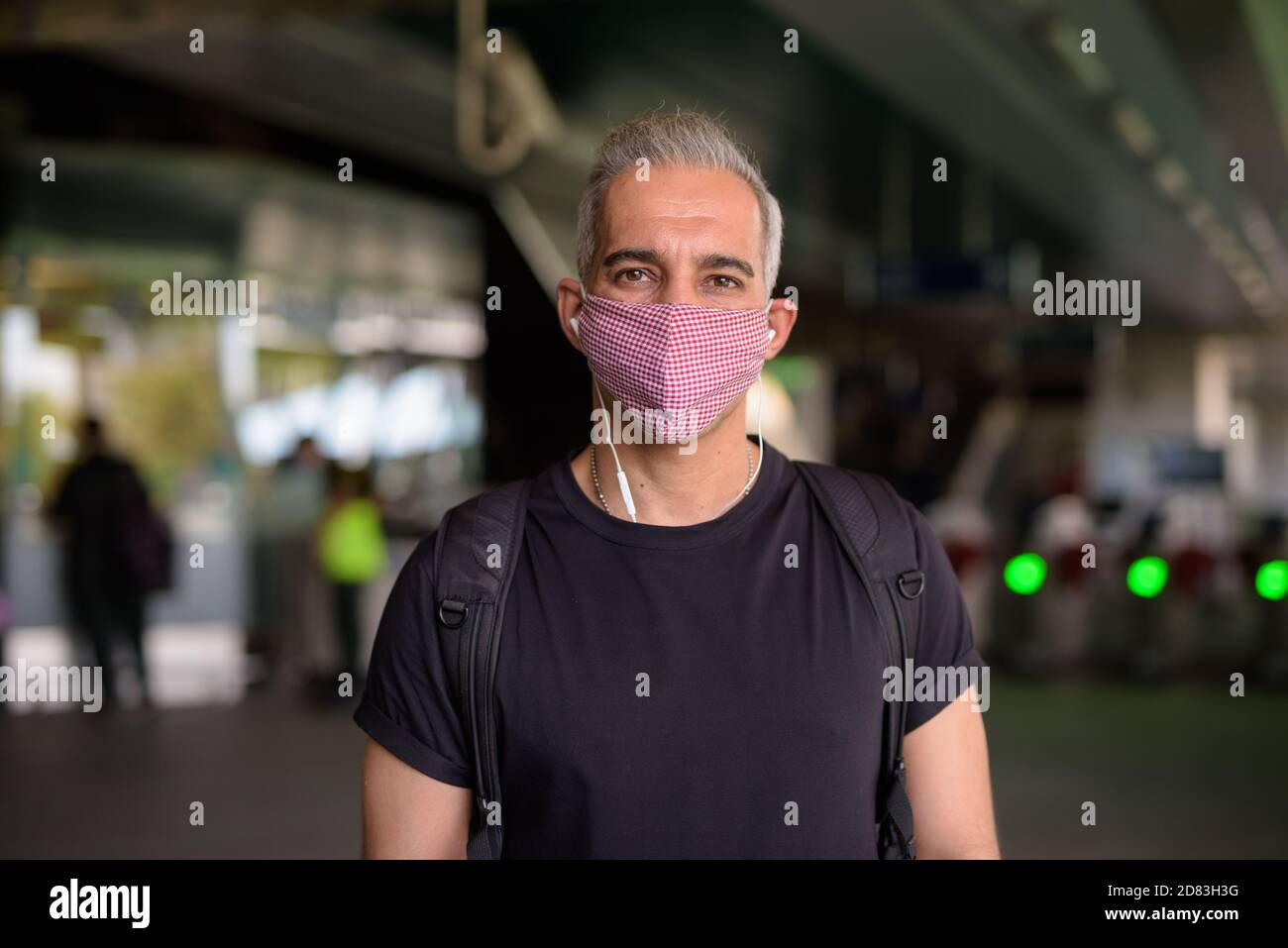 Ritratto dell'uomo persiano con maschera al treno sopraelevato stazione Foto Stock