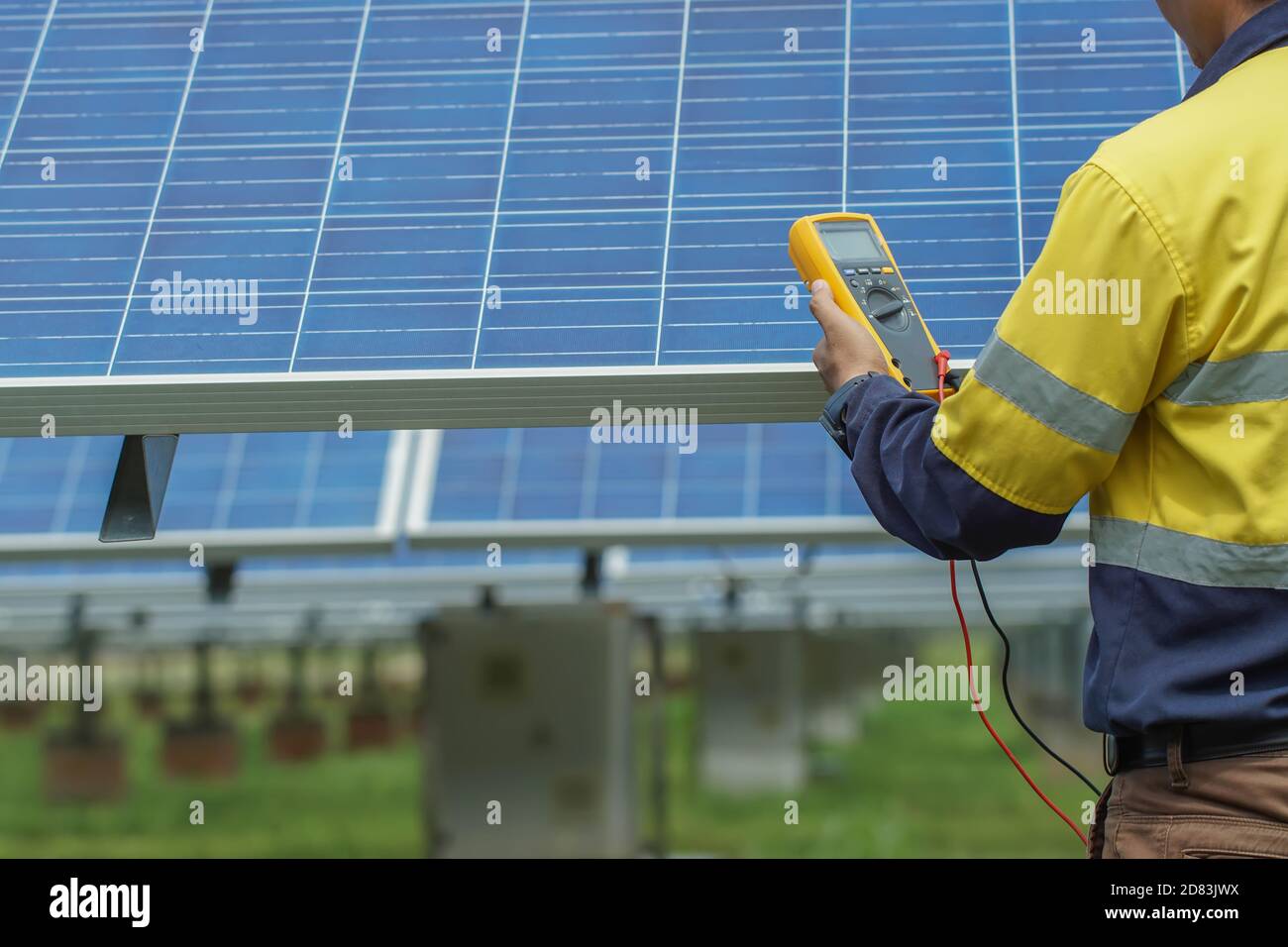 Gli operatori utilizzano il multimetro per misurare la tensione dei fili elettrici prodotti dall'energia solare per confermare il normale funzionamento dei sistemi. Foto Stock