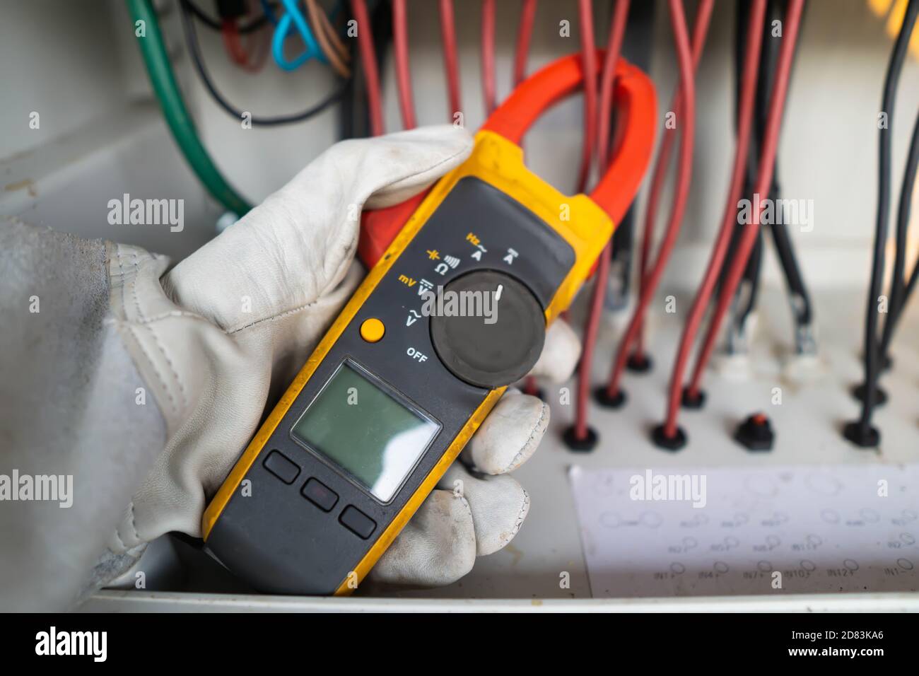 Gli operatori utilizzano il multimetro a pinza per misurare la corrente dei fili elettrici prodotti dall'energia solare per confermare la corrente normale. Foto Stock