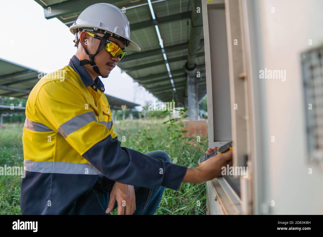 Gli operatori utilizzano il multimetro a pinza per misurare la corrente dei fili elettrici prodotti dall'energia solare per confermare la corrente normale. Foto Stock