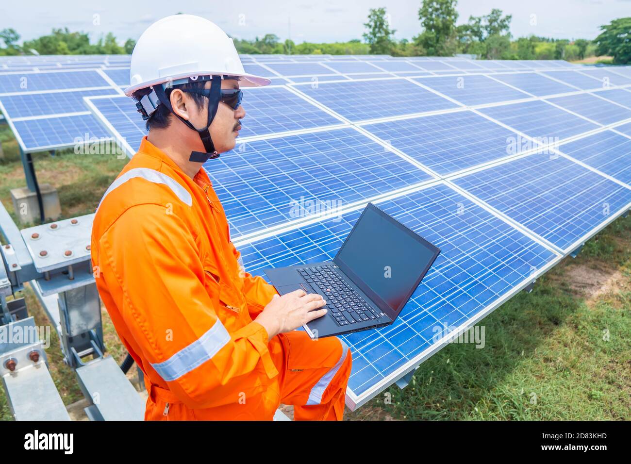 I tecnici caricano i dati dell'energia elettrica su un computer portatile per controllare le prestazioni del pannello solare e confermare il normale funzionamento dei sistemi. Concetti pro Foto Stock