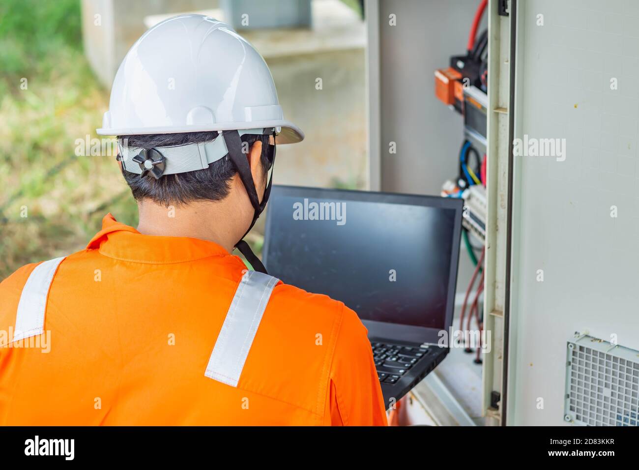 I tecnici caricano i dati dell'energia elettrica su un computer portatile per controllare le prestazioni del pannello solare e confermare il normale funzionamento dei sistemi. Concetti pro Foto Stock