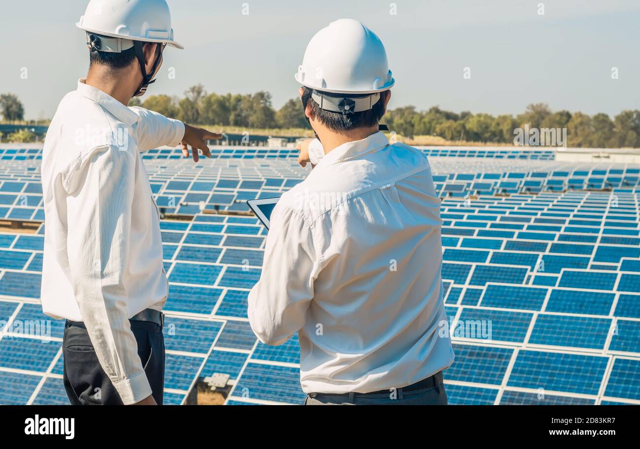 La fattoria solare (pannello solare) con due ingegneri si parla della capacità di produzione, energia alternativa per conservare l'energia del mondo, Fotovoltaico Foto Stock