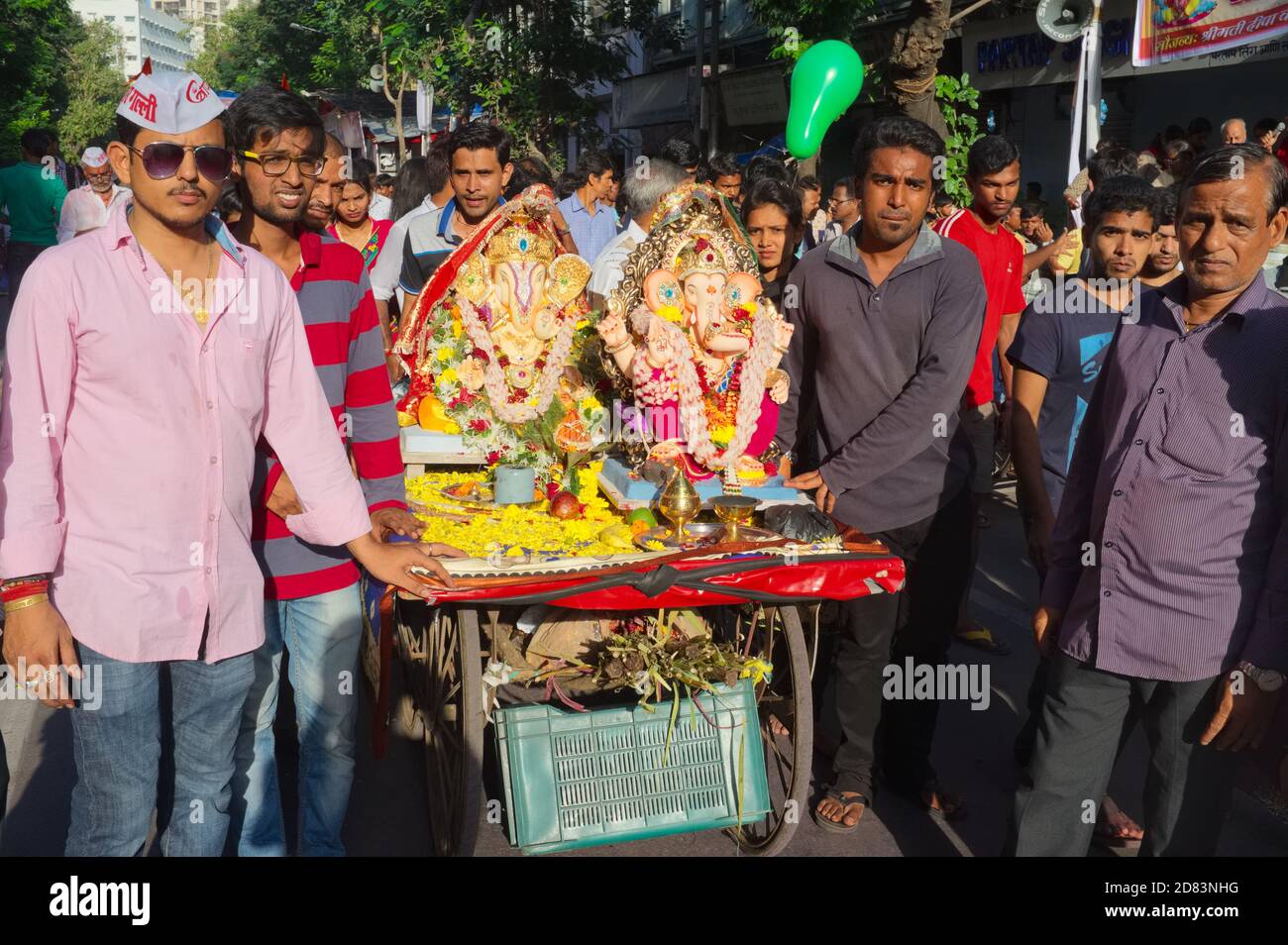Durante il Ganesh Chaturthi o il Ganesh Festival a Mumbai, Maharashtra, India, i cittadini locali rotolano fuori un carro con due figure Ganesh (dio elefante) Foto Stock