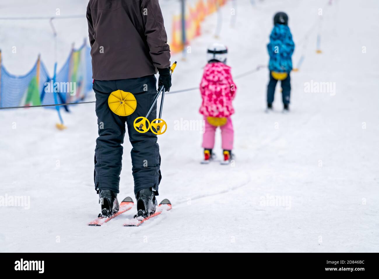La gente sugli sci che è tirata su la collina da un piccolo skilift rotondo  portatile Foto stock - Alamy