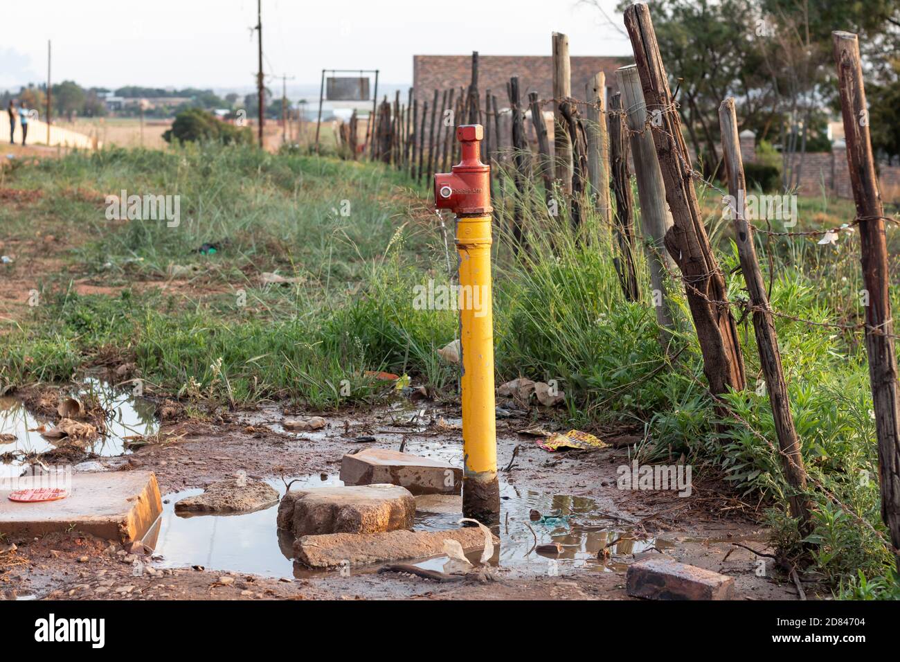 Perdite dalla valvola dell'acqua industriale all'esterno di una vecchia recinzione Foto Stock