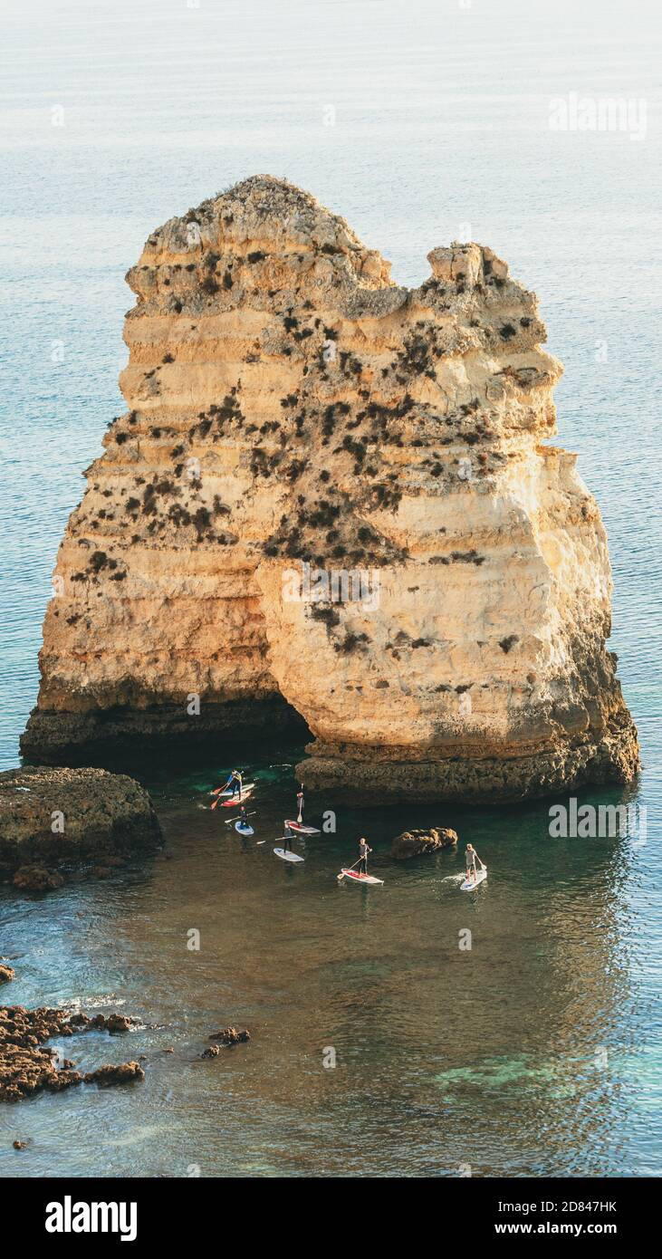 SUP - Stand up paddle group su una scogliera con grotta Foto Stock