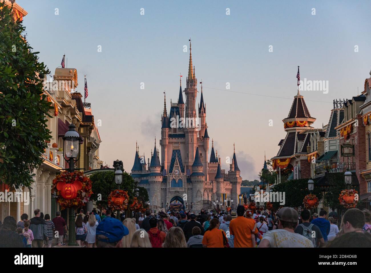 Folle di turisti si dirigono lungo Main Street, Magic Kingdom, Disney World verso il Castello di Cenerderalla all'alba decorata per Halloween Foto Stock