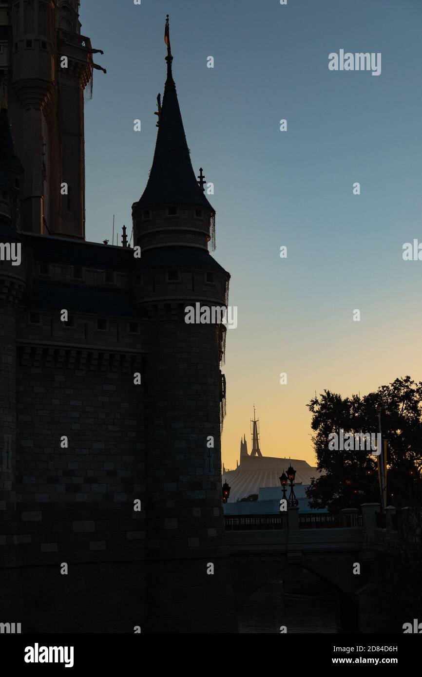 Space Mountain illuminata dall'alba in lontananza dietro le torri silhouette del Castello di Cenerentola, Magic Kindom, Disney World Foto Stock