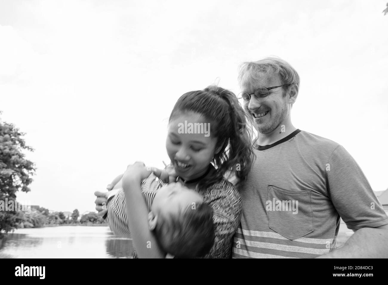 Giovane famiglia multietnica che si unisce al parco Foto Stock