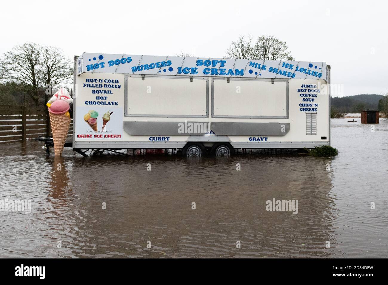 Rimorchio di catering con cartello di gelato in piedi nel parcheggio allagato - Aberfoyle, Stirlingshire, Scozia, Regno Unito - 10 Dicembre 2019 Foto Stock