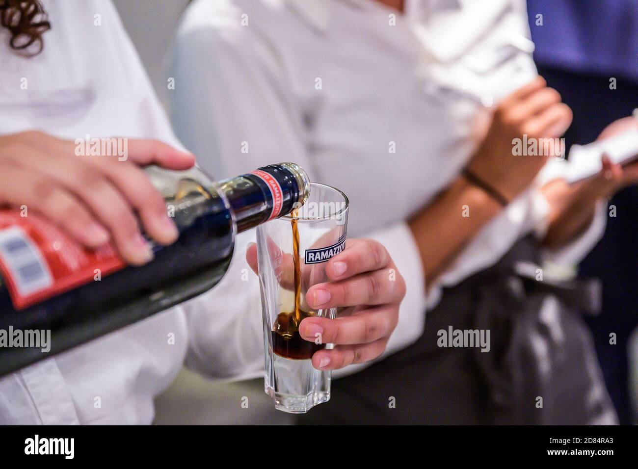 06.07.2019 Koblenz Germania mano con una bottiglia di ramazzotti liquore all'alcol versato in un bicchiere isolato durante un matrimonio di festa. Foto Stock