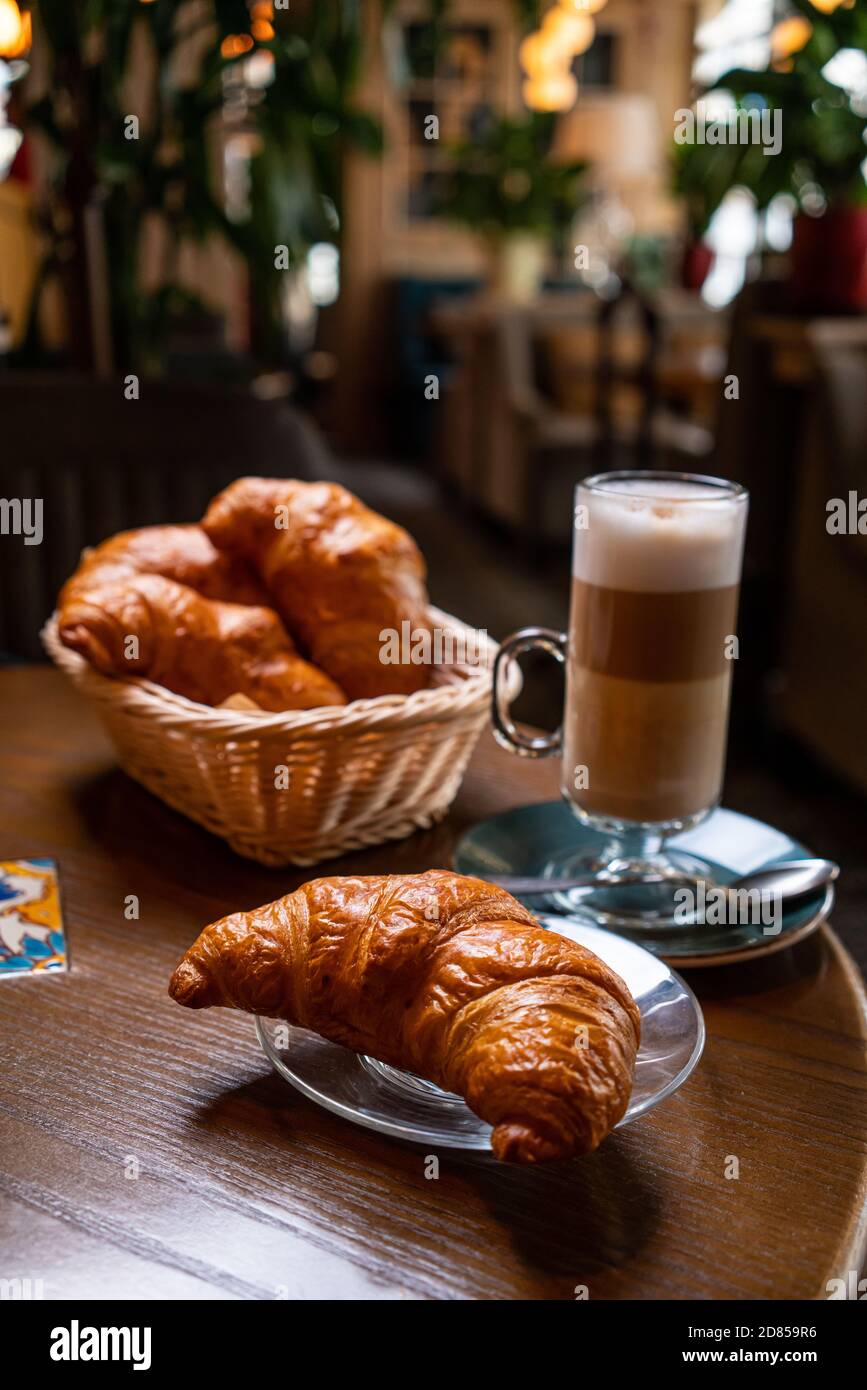 Croissant appena sfornati e tazza di caffè sul tavolo grigio. Spazio di copia. Foto Stock