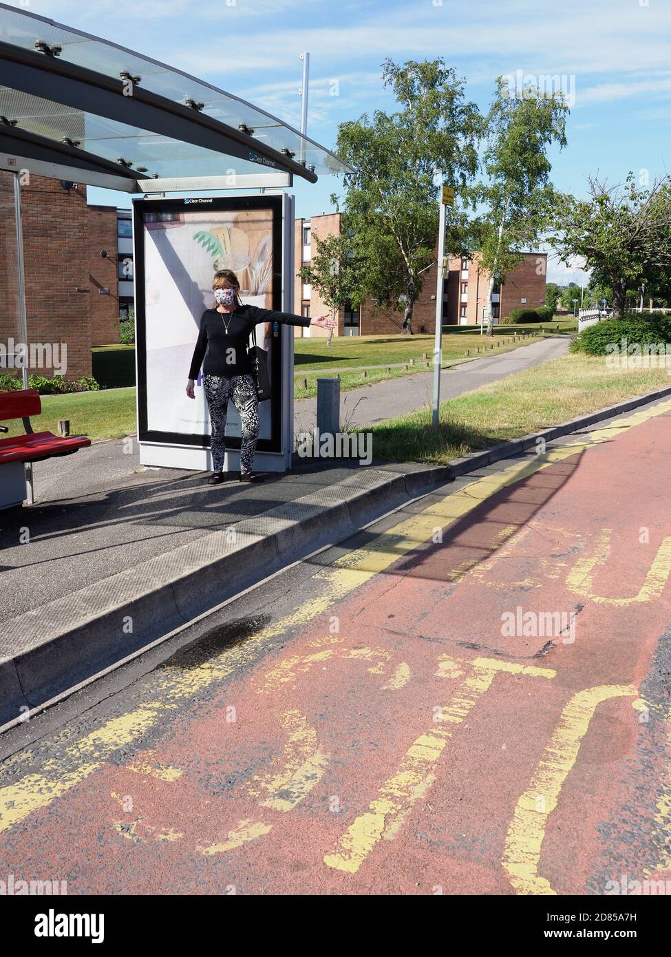 Poole, Dorset, Regno Unito. Giugno 2020. Una donna che indossa una maschera protettiva fa un autobus a una fermata di autobus durante le restrizioni di viaggio Covid. Foto Stock