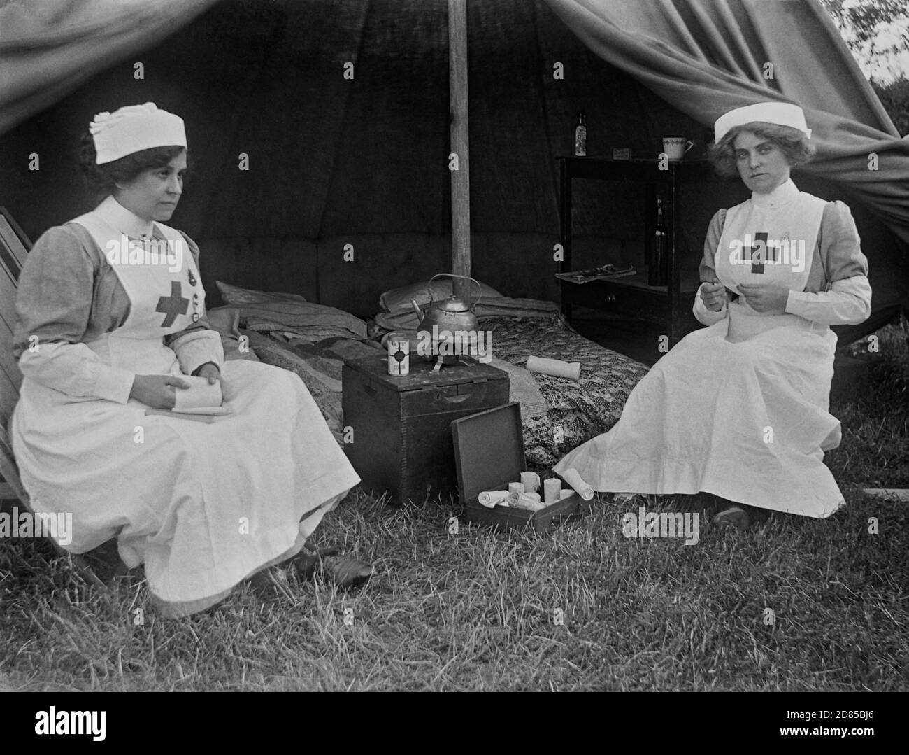 Due infermieri femminili del Devon, distaccamento di aiuto volontario, seduti fuori da una tenda aperta con attrezzature in esposizione. Francia, circa 1915. Foto Stock