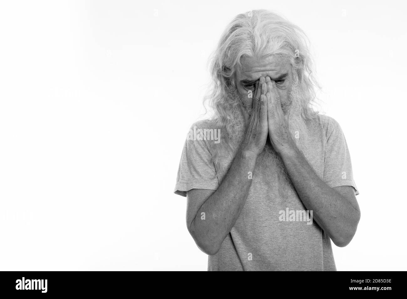 Studio shot di senior uomo barbuto piangendo mentre copre il viso con entrambe le mani Foto Stock