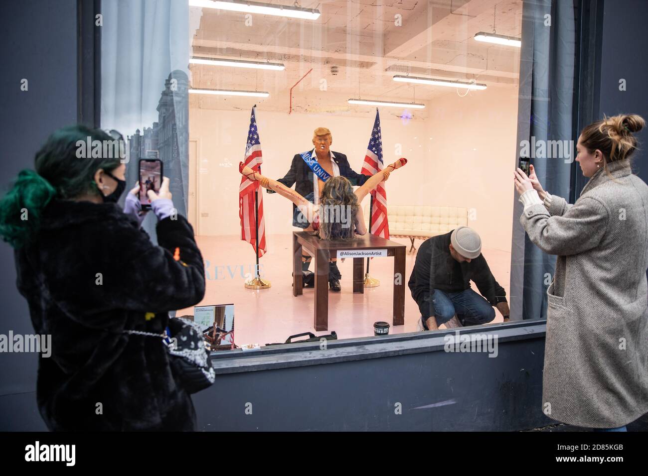 I REDATTORI NOTANO IL CONTENUTO i membri del pubblico fotografano una scultura recentemente installata intitolata "Trump e Miss Universo scultura" dell'artista Alison Jackson, raffigurante il presidente degli Stati Uniti Donald Trump, alla Soho Revue Gallery, Londra. Foto Stock