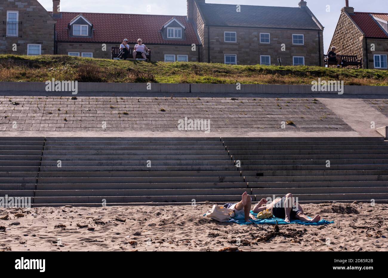 Persone che prendono il sole sulla spiaggia, Whitby, Inghilterra, Regno Unito Foto Stock