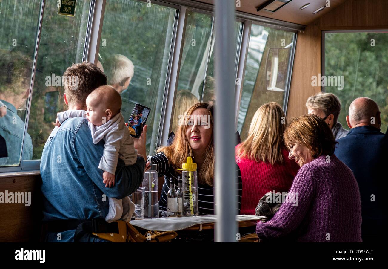 Famiglia in pub con bambino, donna che mostra telefono uomo, Wroxham, Norfolk, Inghilterra, UK Foto Stock