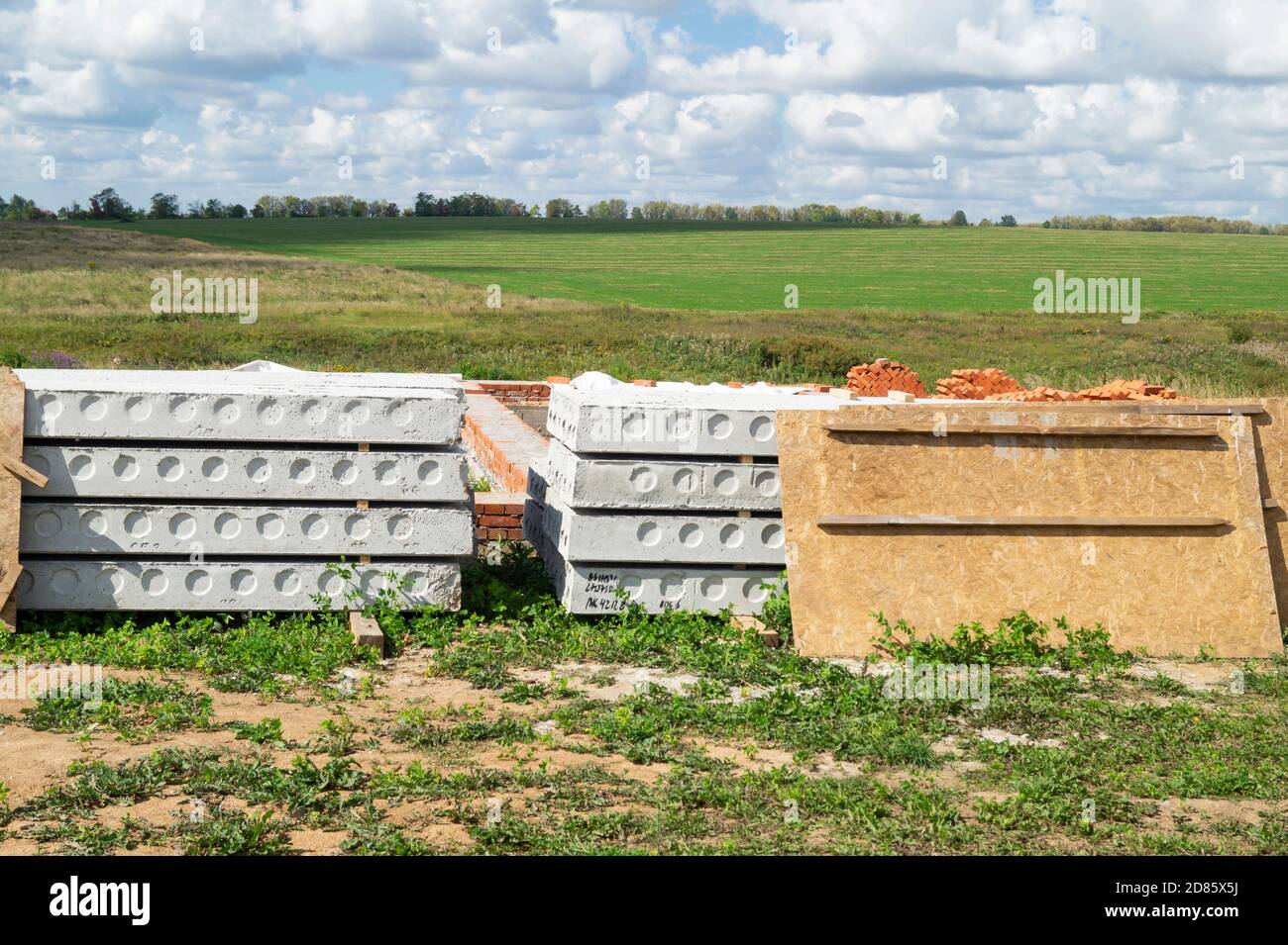 La costruzione della fondazione per la costruzione in campo su sfondo cielo blu. Anno paesaggio al giorno solare Foto Stock